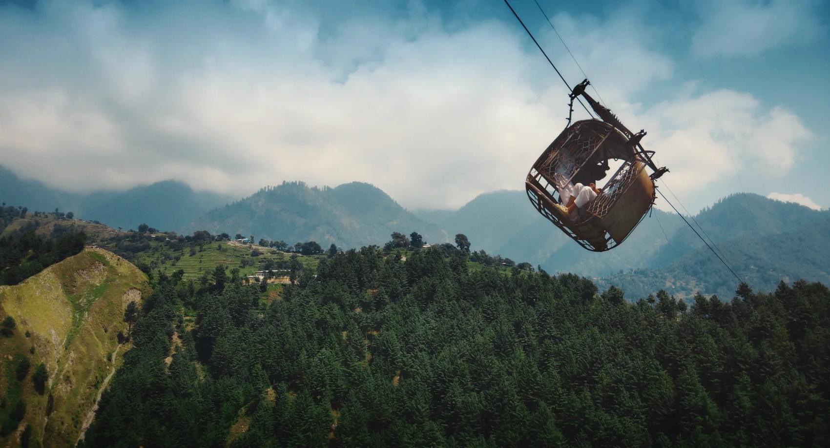 A cable car suspended over a valley in the Himalayan foothills